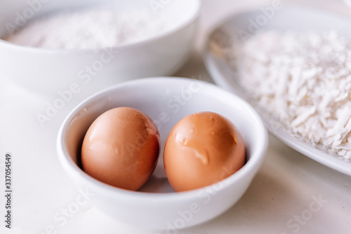 Eggs in white bowl ready to use. White background. Happy easter.