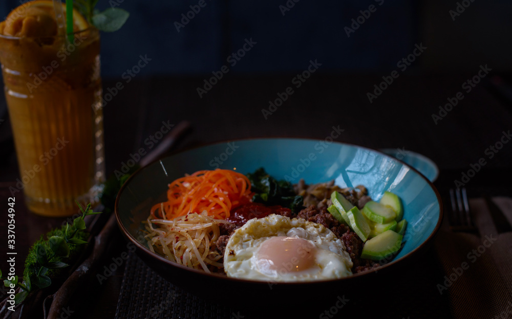 Korean dish bibimbap - mixed rice with meat and assorted vegetables on dark background Korean dish bibimbap - mixed rice with meat and assorted vegetables on dark background