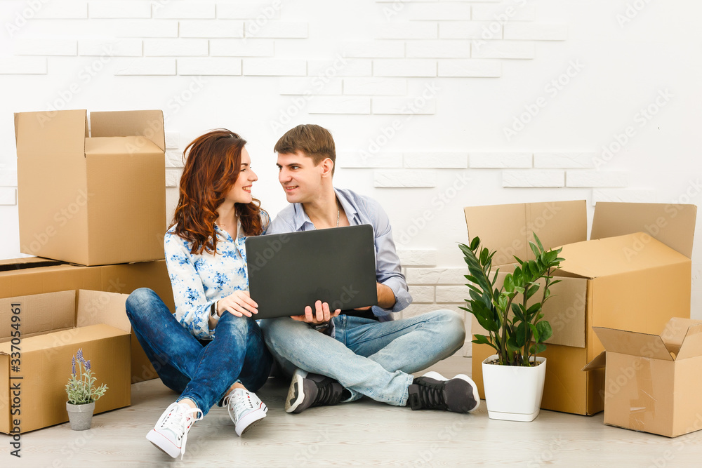 Smiling couple leaning on boxes in new home Smiling couple leaning on boxes in new home