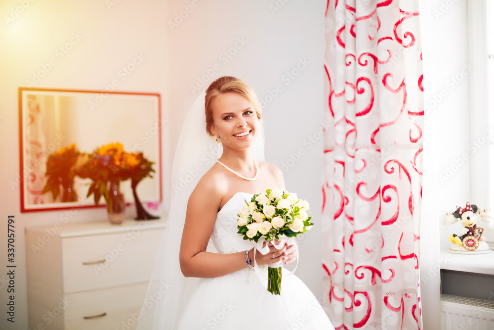 A elegant and beautiful bride at home standing near window A elegant and beautiful bride at home standing near window
