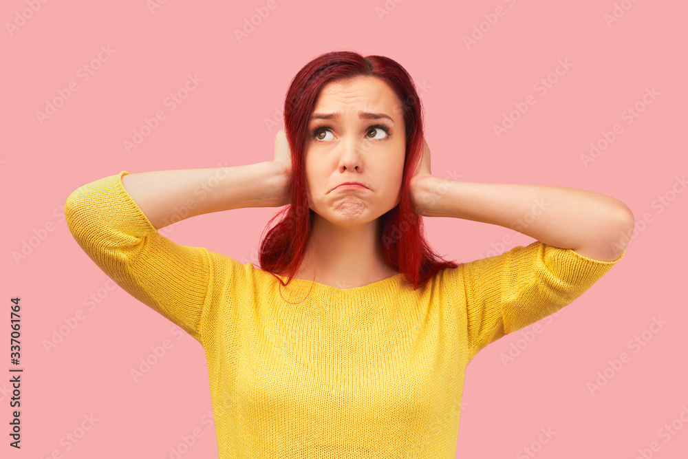 Photo of desperate annoyed woman keeps hands on head, holds palms on ears, ignores annoying sound, feels depressed, has many debts and financial crisis. Young girl stands isolated on background Studio Photo of desperate annoyed woman keeps hands on head, holds palms on ears, ignores annoying sound, feels depressed, has many debts and financial crisis. Young girl stands isolated on background Studio