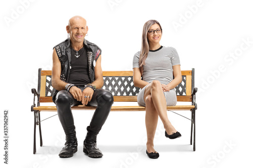 Bild auf Leinwand Punk in a leather vest and pants sitting on a bench next to a young blond woman