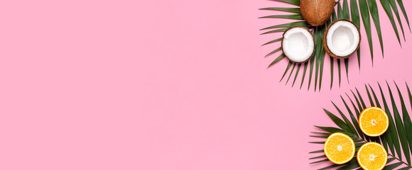 Summer tropical composition. Green tropical leaves of palm trees and monstera, coconut, orange on bright pink background. Flat lay, top view, copy space. Creative background food, fruit