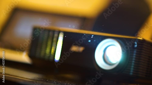 Modern technology, black projector on table prepared to broadcast video presentations on screen photo