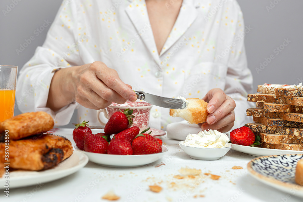 Unrecognizable woman having breakfast in pajamas at home in quarantine Unrecognizable woman having breakfast in pajamas at home in quarantine