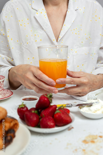 Unrecognizable woman having breakfast in pajamas at home in quarantine