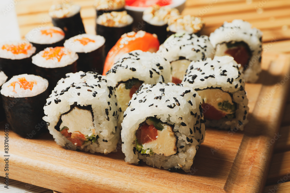 Delicious sushi rolls on wooden background, close up. Japanese food Delicious sushi rolls on wooden background, close up. Japanese food
