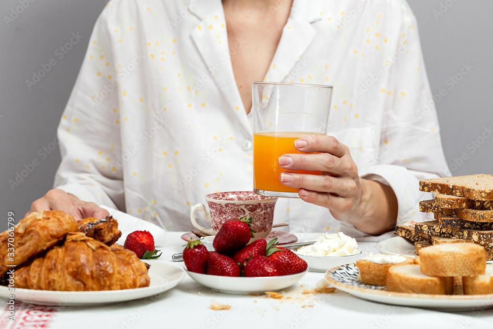 Unrecognizable woman having breakfast in pajamas at home in quarantine Unrecognizable woman having breakfast in pajamas at home in quarantine