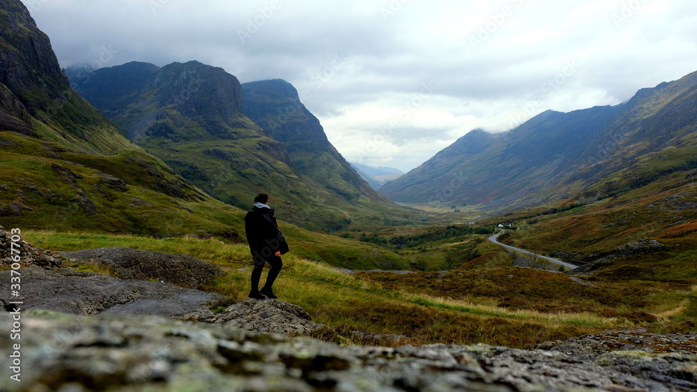 Girl enjoying a view of the Glencoe valley mountain viewpoint, Scotland