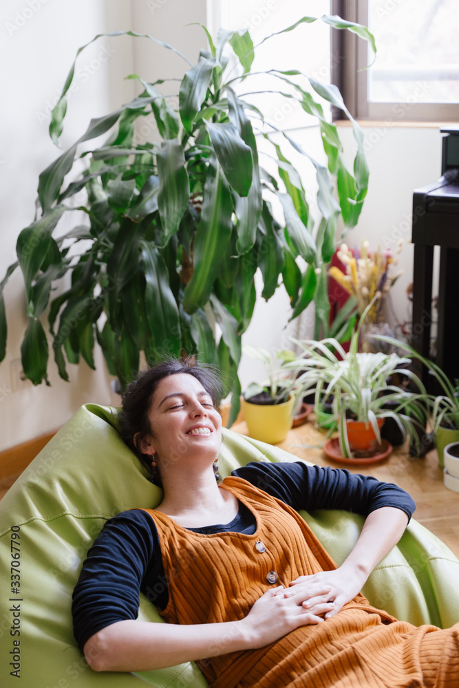 Portrait of cheerful woman resting at home. Stay home concept. Vertical side view of woman relax and laying down during quarantine time of coronavirus. People lifestyle during covid 19 concept. Portrait of cheerful woman resting at home. Stay home concept. Vertical side view of woman relax and laying down during quarantine time of coronavirus. People lifestyle during covid 19 concept.