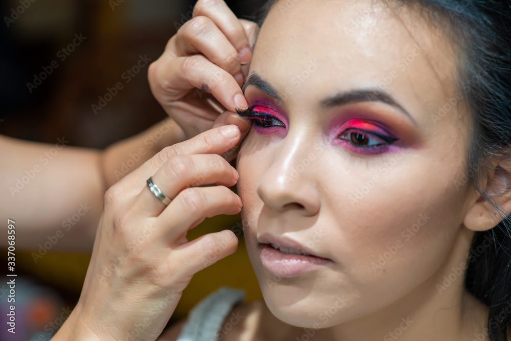 Makeup artist applying false eyelash.Make up artist doing professional make up of beautiful young woman. Makeup artist applying false eyelash.Make up artist doing professional make up of beautiful young woman.