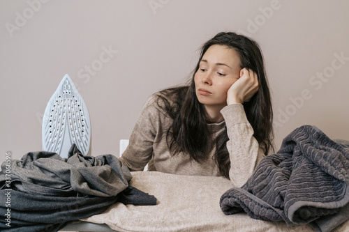 A sloppy girl does not like to stroke. Depression in a housewife. Upset woman from daily cleaning, ironing and disinfection. Tired mom stroking things