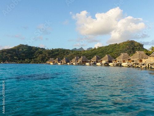 Overwater Bungalows over Turquoise Lagoon with Reef at Sunset in Bora Bora French Polynesia