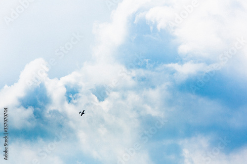 空に浮かぶ雲、そに映り込んだ小さなセスナ機