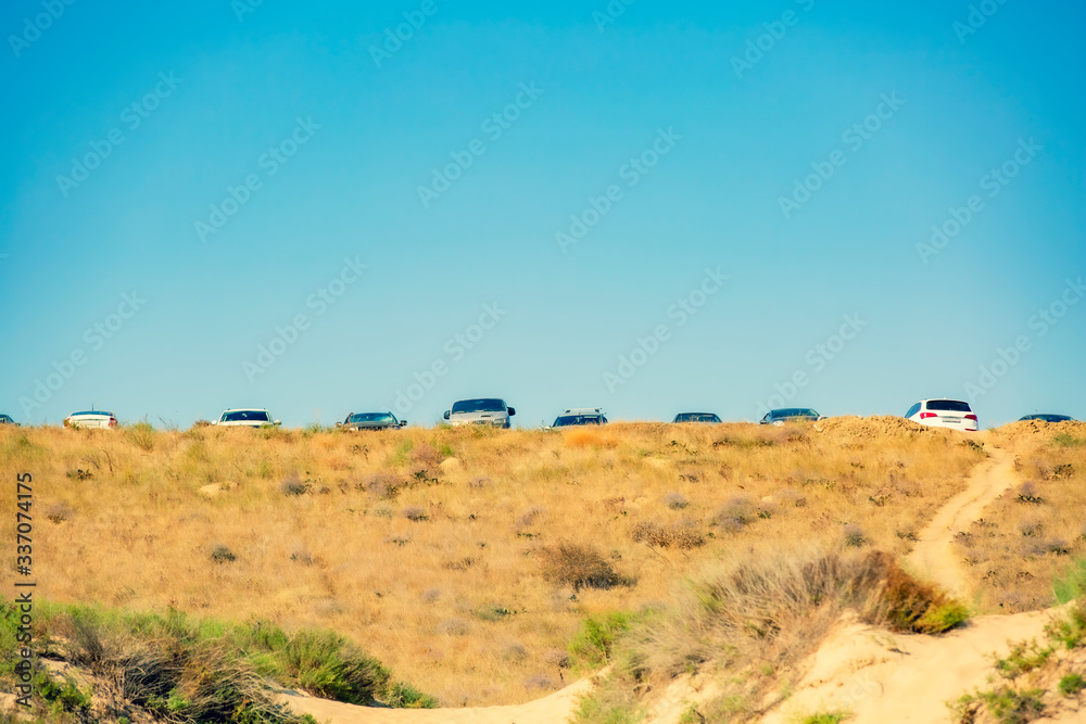 Tourists parked their cars on a hill on the way to the famous sandy beach. Copy space