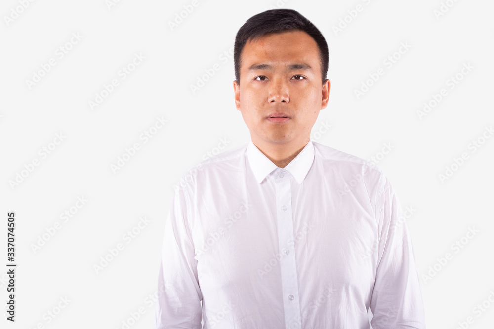 Attractive chinese man in white shirt in apathy looks at camera. Human portrait Attractive chinese man in white shirt in apathy looks at camera. Human portrait