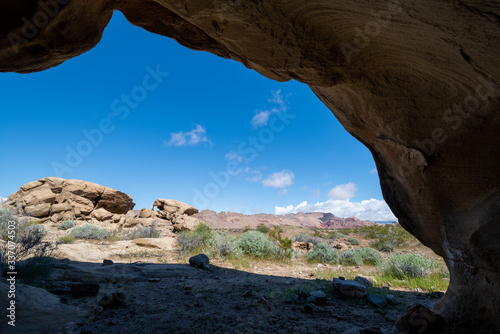 Grotto Overhang Silhouette in sulferous yellow sandstone frames Bitter Ridge in Gold Butte National Monument, Clark County, Nevada, USA photo