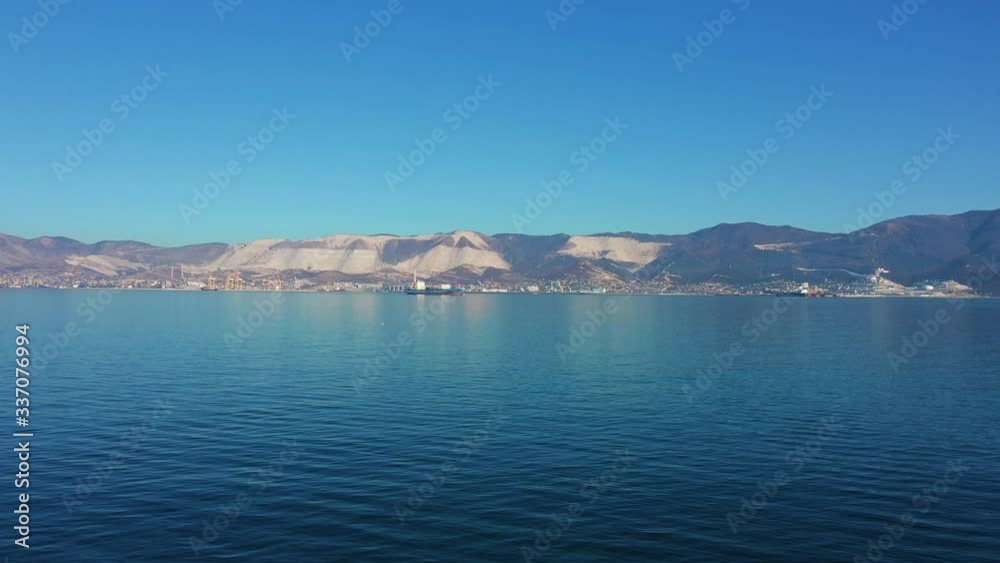 Aerial view of sea bay with calm water and mountains on background at sunny day Aerial view of sea bay with calm water and mountains on background at sunny day