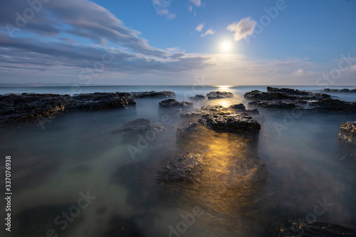 full moon rise over the sea and tidal pools at the beach © Sacha Specker