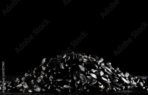 Obraz na płótnie a hill of sunflower seeds on a black background w salonie