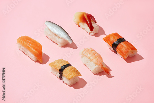 Sushi set of different nigiri idea, creative top on a pink background isolated photo