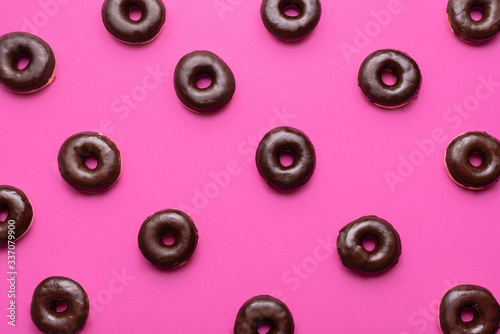Tela Chocolate donuts on pink background. Glazed doughnuts