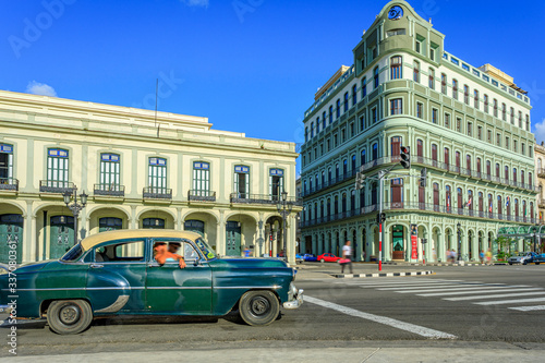 Havana Cuba Green vintage classic american car in a typical colorful street with sunny blue sky 