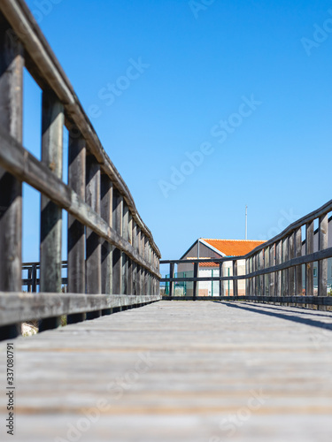 Composición pasarela con valla de madera en la playa junto a caseta