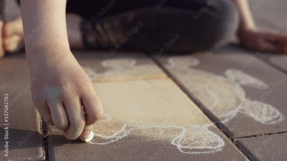4K. Dirty girl draws silhouette of a corona virus with a chalk on a pavement. Poor sad little child - Stay home and self isolation in quarantine concept. 4K. Dirty girl draws silhouette of a corona virus with a chalk on a pavement. Poor sad little child - Stay home and self isolation in quarantine concept.