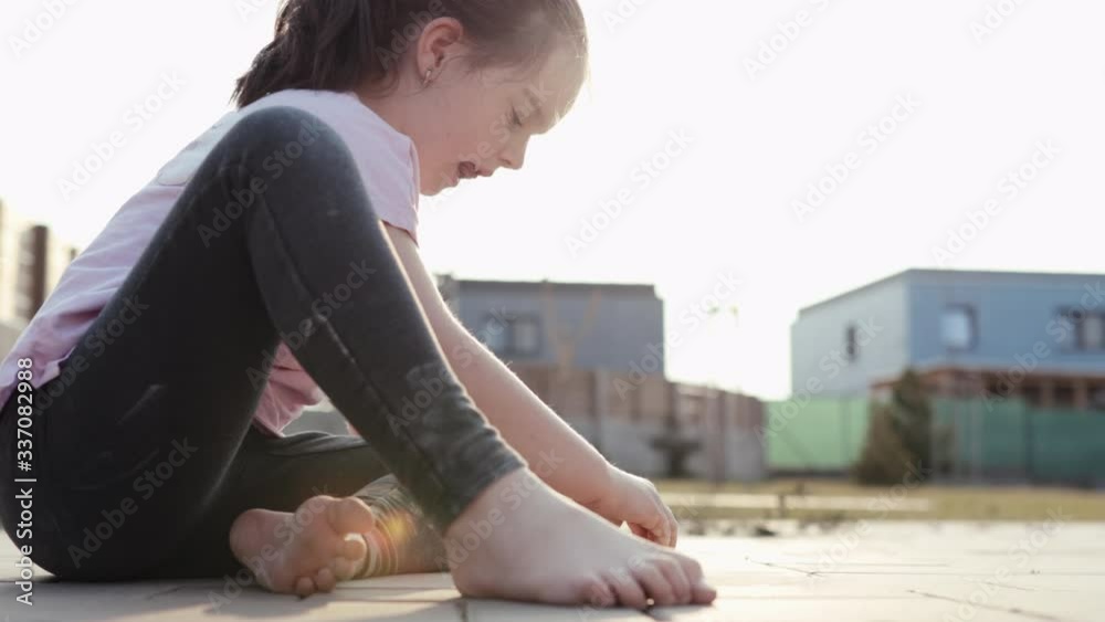 4K. Poor dirty little girl draws with a chalk on a pavement. Child - Stay home and self isolation in corona virus quarantine concept.