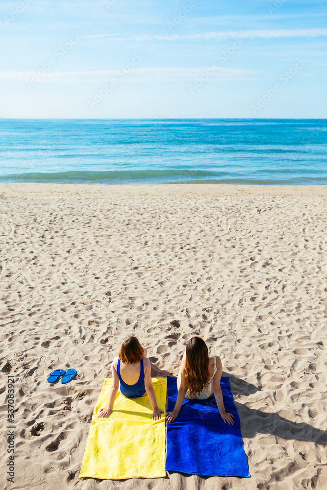 Overhead of female best friends lying on the beach. Overhead of female best friends lying on the beach.