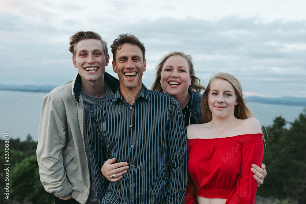 Family of four with teenagers together outside Family of four with teenagers together outside