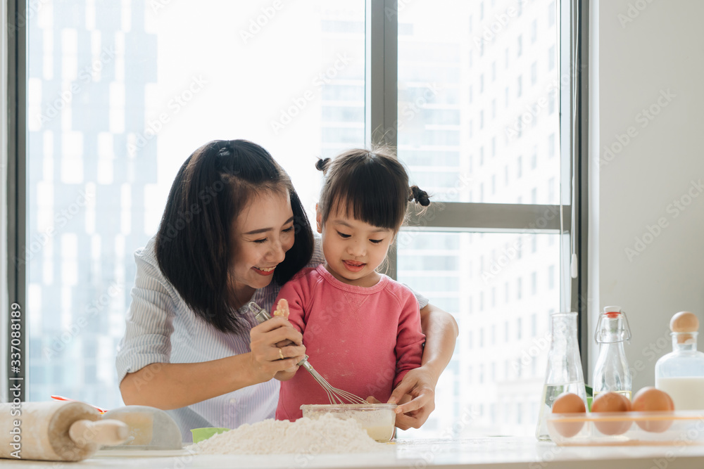 Beautiful blond mom teaching her daughter cooking on the kitchen. Beautiful blond mom teaching her daughter cooking on the kitchen.