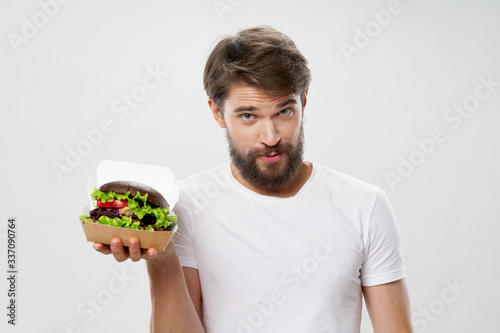 young man holding a bowl of salad