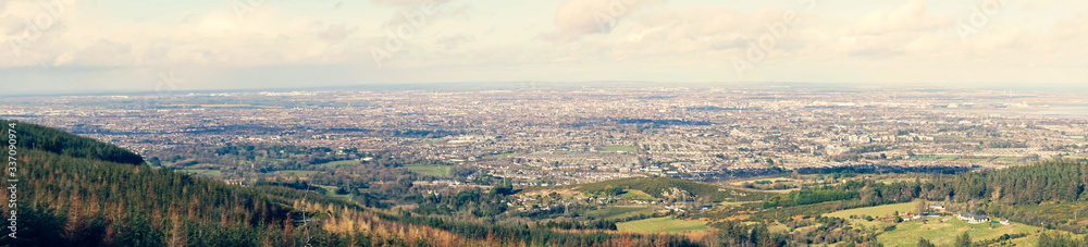 Stunning panoramic view of Dublin city and port from Ticknock, 3rock, Wicklow mountains. Gorse and forest plants in foreground during calm weather