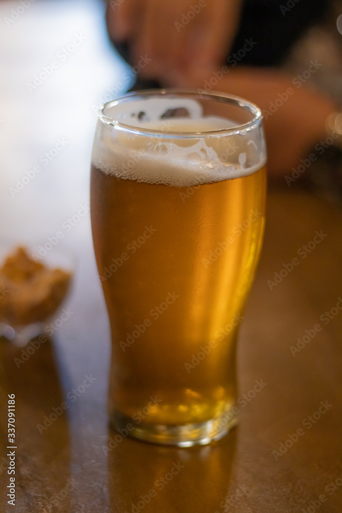 Cerveza en mesa de madera con maní en un recipiente de fondo Cerveza en mesa de madera con maní en un recipiente de fondo