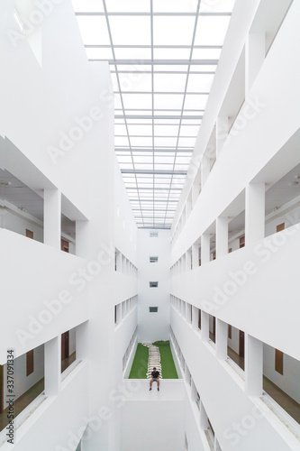 Perspective view of a young man sitting inside a white building