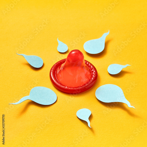 Paper sperm around red condom.