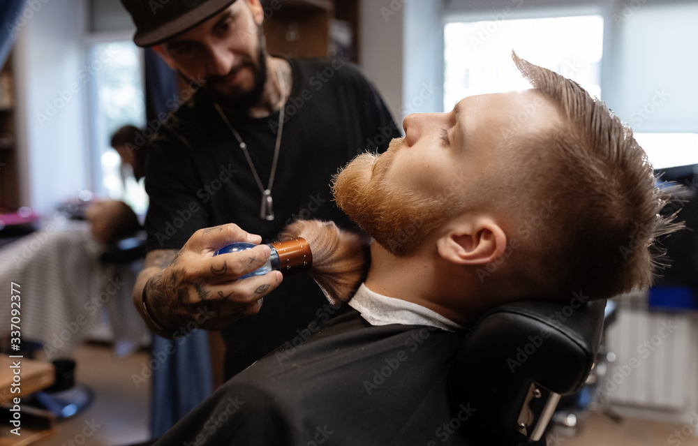 Barber grooming handsome man finishing cut Barber grooming handsome man finishing cut