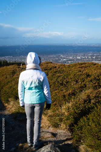 Tourist resting after a hike and enjoying the beautiful view of Dublin, green rolling Irish hills and mountain peaks. View from 3 Rock,Wicklow Mountains, Ireland. © Marcin