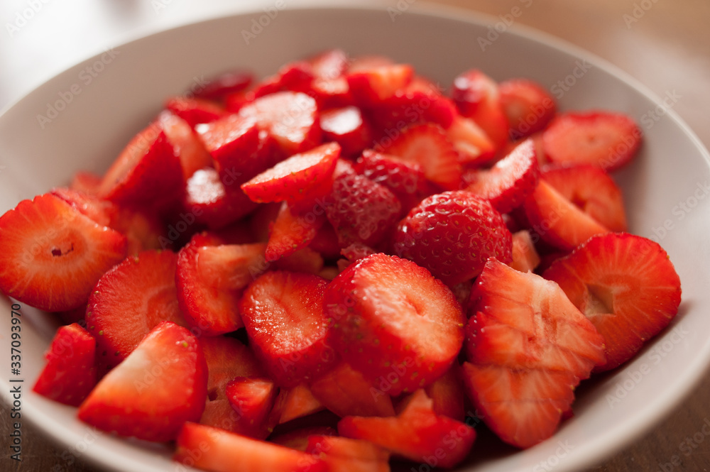 close up of sliced strawberries on a white plate close up of sliced strawberries on a white plate