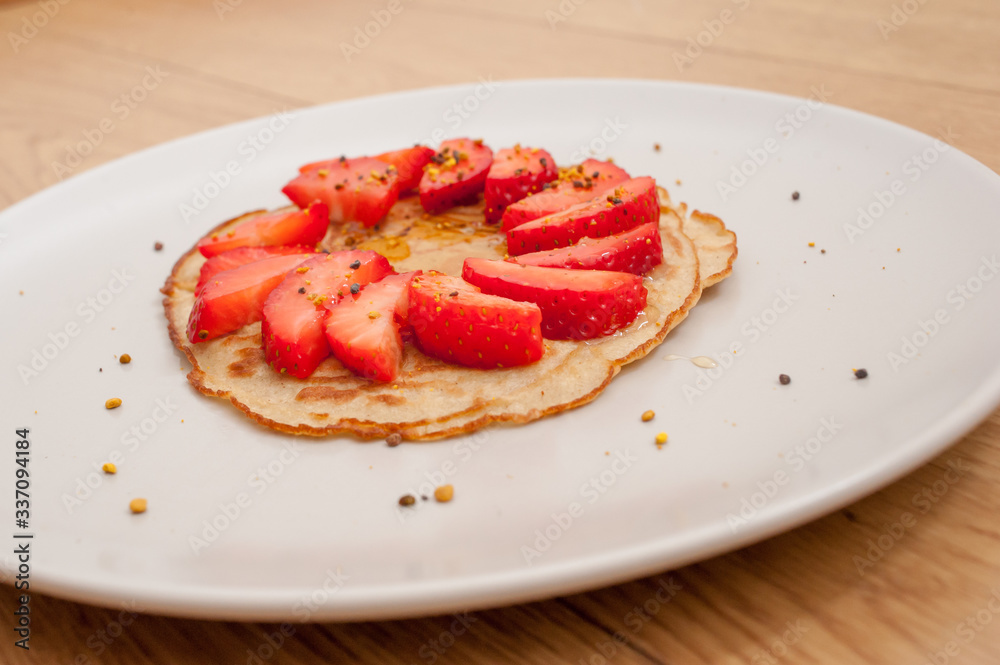 strawberry pancake on a white plate in a wooden table strawberry pancake on a white plate in a wooden table