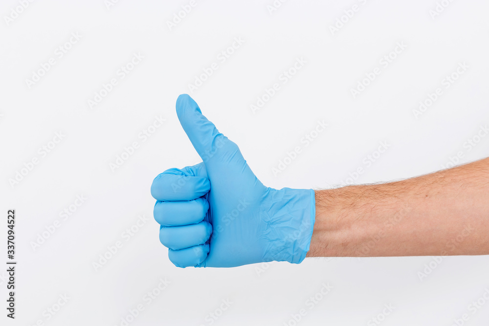 Hand of surgeon in blue medical glove showing Ok sign, isolated on a white background