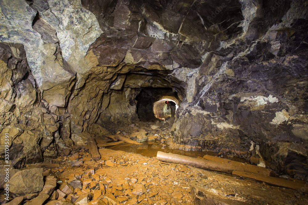 Underground abandoned platinum ore mine tunnel with miner