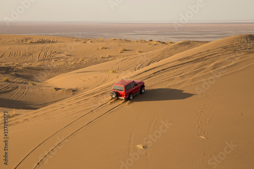 A beautiful view of the red car in the desert