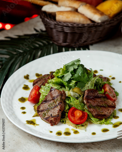 grilled beef steak pieces served with vegetables and pesto sauce