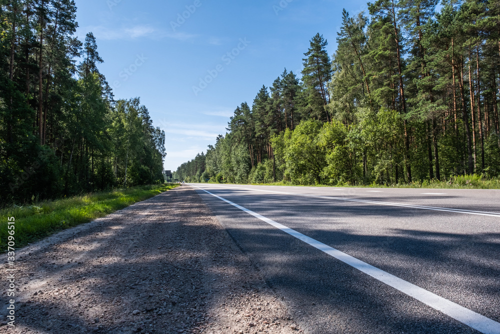 Fototapeta premium Empty highway, two lane road and the forest. asphalt road travel concept.