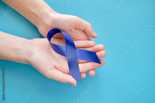 Blue ribbon on on two hands is a symbol of the problem of Stevens-Jones syndrome, colon cancer, problem of hydranencephaly, chronic fatigue syndrome, myalgic encephalomyelitis photo
