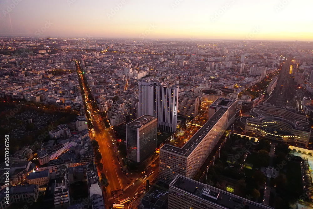 Obraz premium Ausblick auf die beleuchteten Straßen und Gebäude von Paris, Frankreich bei Nacht in Montparnasse