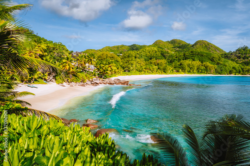 Mahe Island, Seychelles. Holiday vocation on the beautiful exotic Anse intendance tropical beach. Ocean wave rolling towards sandy beach with coconut palm trees photo